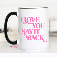 White mug with pink text 'I LOVE YOU SAY IT BACK' on a white background