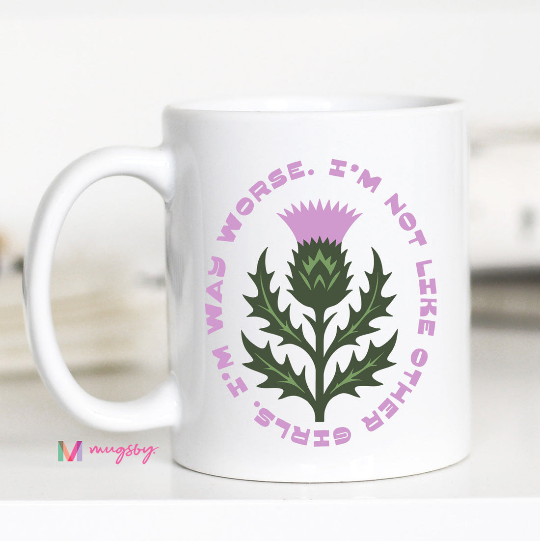 White mug with a thistle design and text on a white background