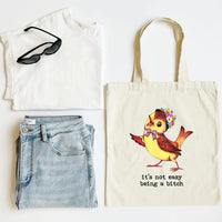 White tank top, blue jeans, black sunglasses, and a tote bag with a colorful bird design on a white background.