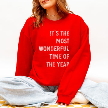 Person wearing a red sweatshirt with white text sitting on a couch.