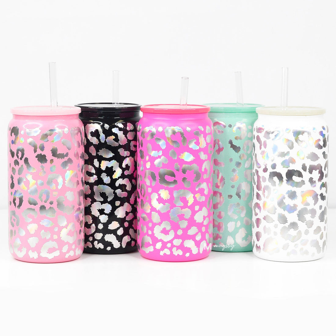A collection of five holographic glitter glasses in pink, black, green, and white, each with a matching plastic lid and clear plastic straw.