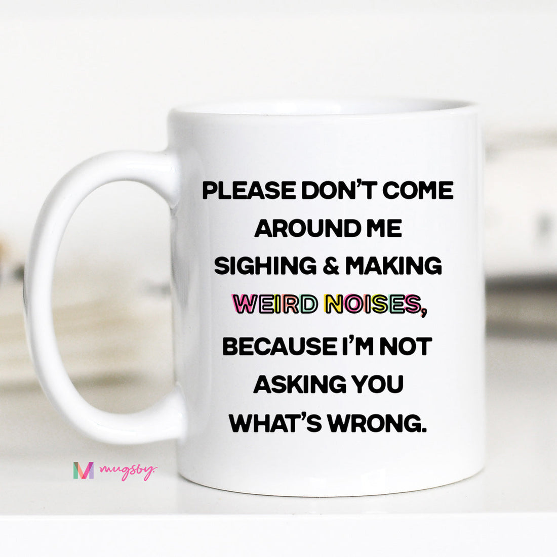 A white ceramic coffee mug with black text and a black handle, featuring the phrase &