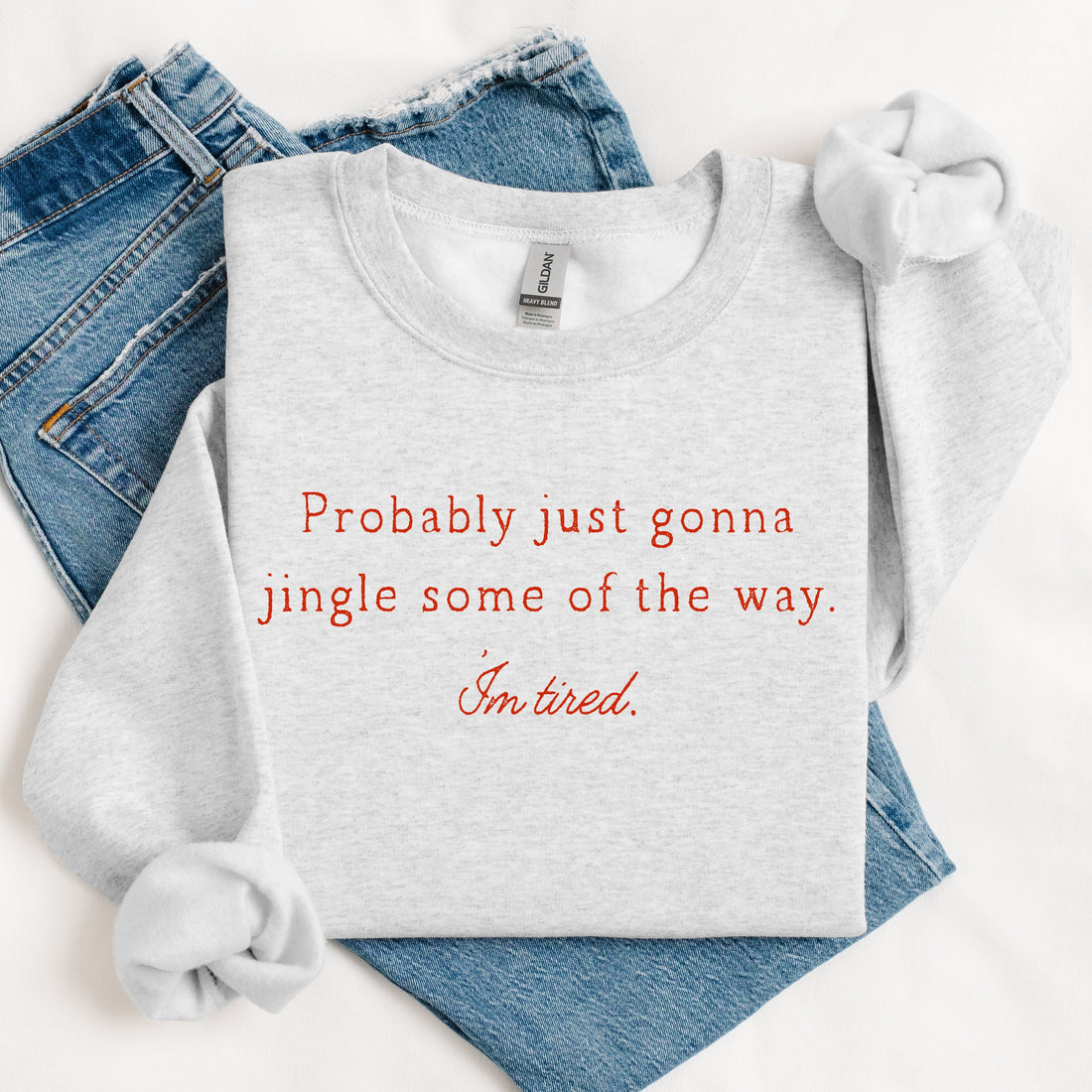 Gray sweatshirt with red text and blue jeans on a white background