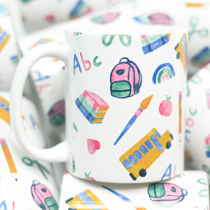 Back to school Mug featuring books, backpack, school bus apples, heart and rainbows