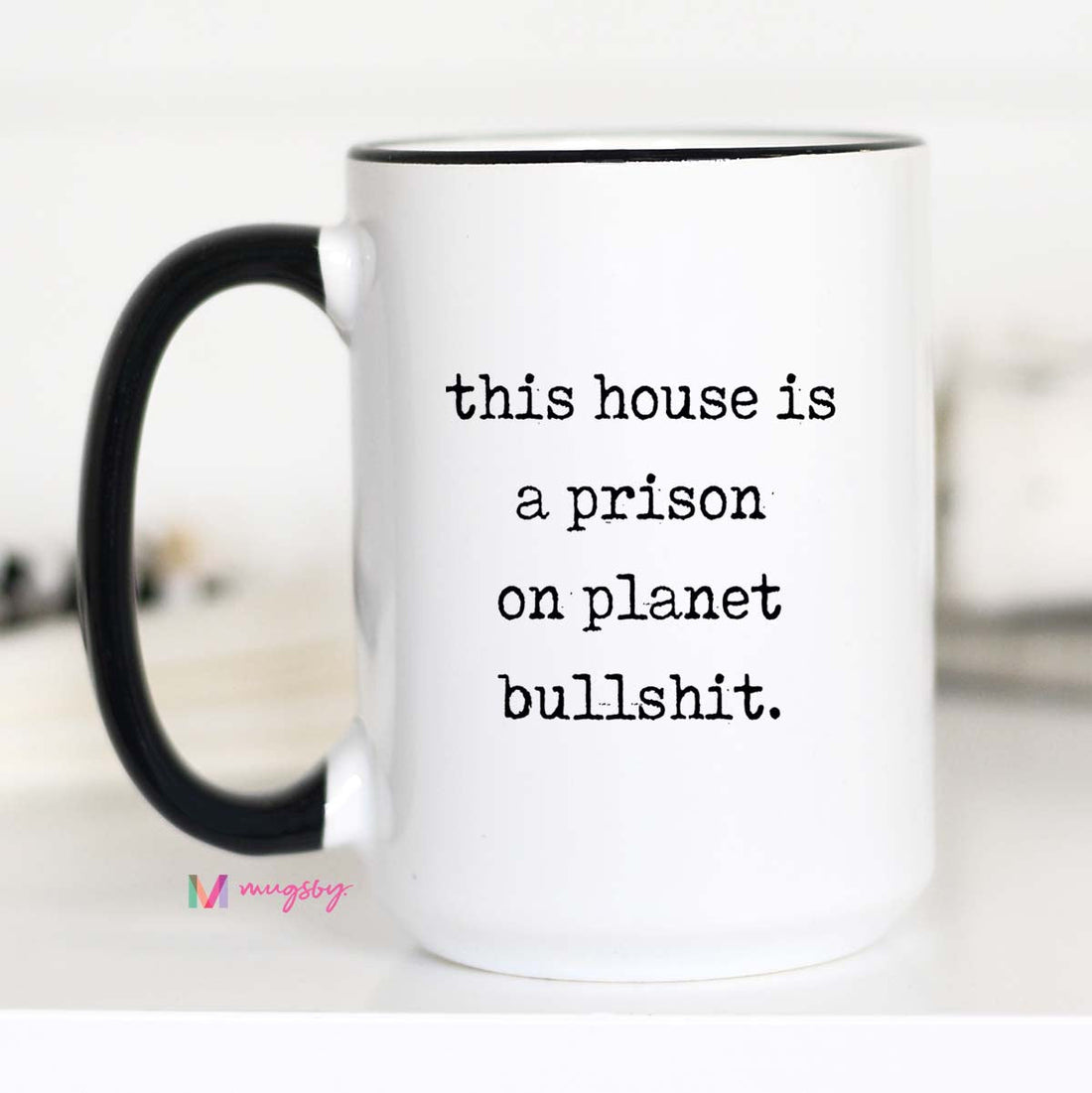 White mug with black handle and text on a white background