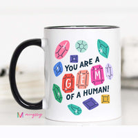 Mug with colorful gemstone designs and text on a white background