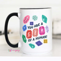 Mug with colorful gem illustrations and text on a white background